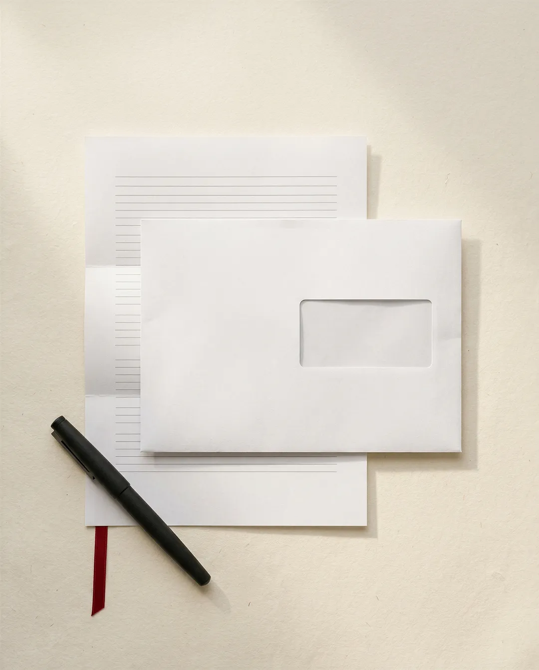 Carta intestata e busta con finestra, con penna stilografica su carta chiara